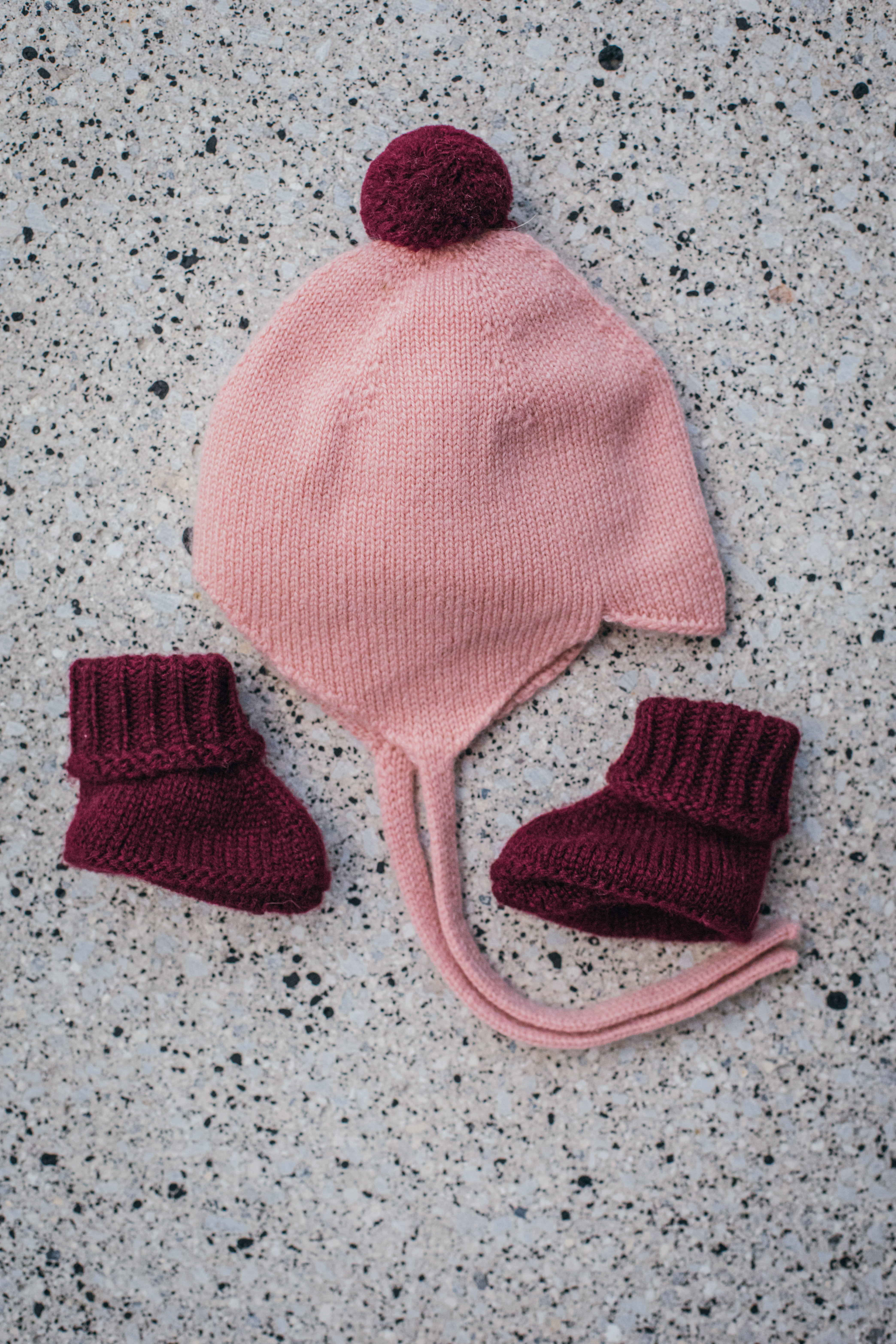Rosie Sugden Cashmere's Baby Bonnet in Coral with Damson Pom-Pom