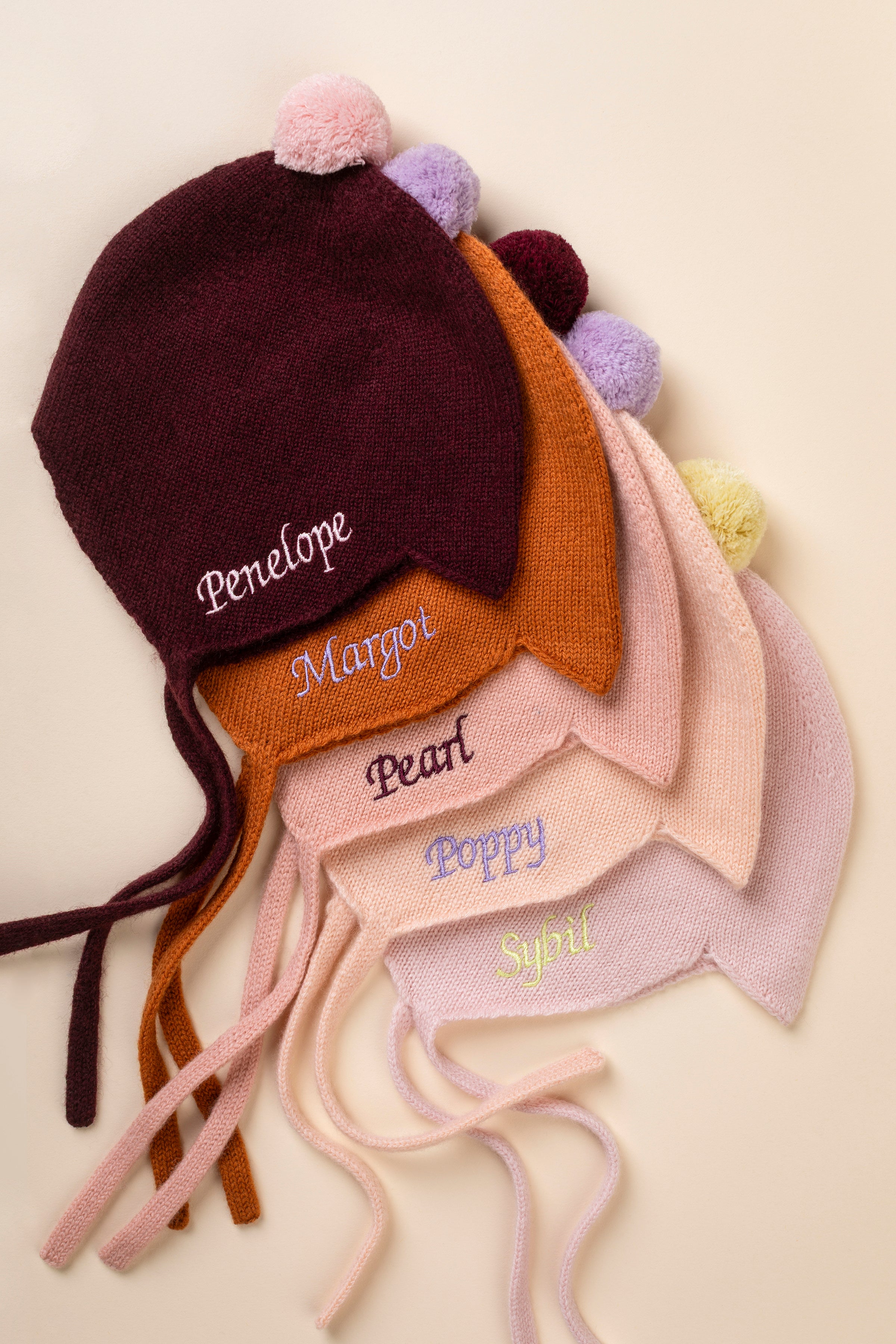 Rosie Sugden Cashmere's Baby Bonnet in Coral with Damson Pom-Pom